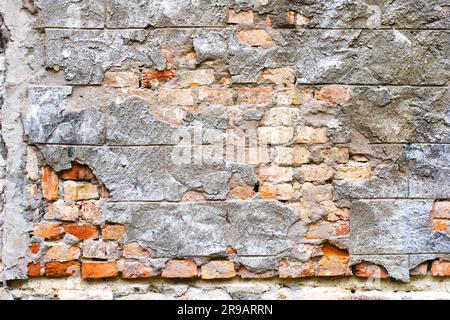 Frammento del vecchio muro in mattoni con stucco bianco Foto Stock