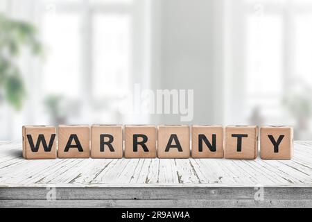 Segno di garanzia su una scrivania di legno in un ambiente luminoso con piante verdi Foto Stock