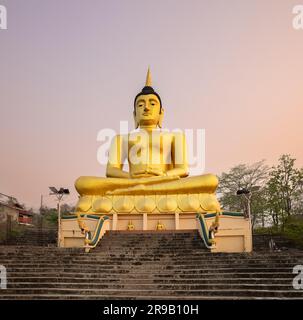 Buddha d'oro che si affaccia su Pakse al tramonto. Wat Phousalao. Laos Foto Stock