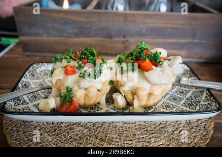 Tortine cremosa con pollo e salsa agli asparagi e rabboccato con prezzemolo su una piastra su un tavolo di legno in un ristorante che serve cibo Foto Stock