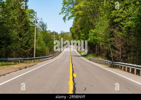 Un tratto di una strada statale 62 a due corsie a Tionesta, Pennsylvania, USA, in una soleggiata giornata primaverile Foto Stock