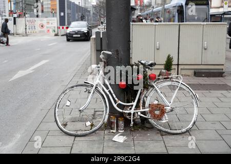 Monaco di Baviera, Germania - 23 dicembre 2021: Bicicletta abbandonata vecchia e obsoleta dipinta di bianco con decorazioni natalizie in una strada a Monaco, Germania Foto Stock