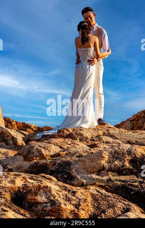 Giovane coppia cinese in posa per le fotografie di matrimonio sulle rocce, porto di Stanley, Hong Kong, sar, Cina Foto Stock