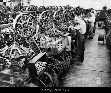 Stati Uniti: c. 1939 lavoratori della fabbrica che disegnano filo sulle bobine. Foto Stock