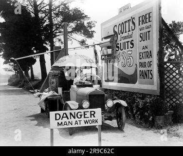 Hollywood, California: 1928 l'attore Glenn Tryon dimostra il suo dispositivo automatico di poster per banconote che fa risparmiare lavoro nel film "The Gate Crasher", diretto da William Craft. Foto Stock