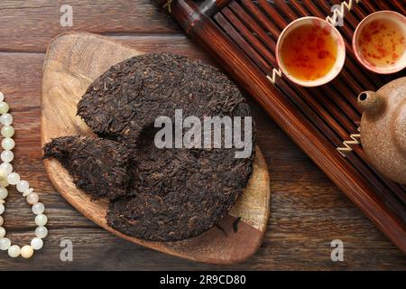 Composizione piatta con tè pu-erh su tavolo in legno Foto Stock