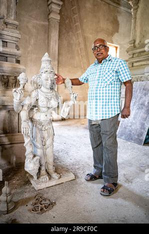 PRODUZIONE - 24 giugno 2023, Berlino: Vilwanathan Krishnamurthy, membro del Consiglio di amministrazione del tempio, si trova accanto a una statua dei guardiani del tempio nel cantiere del tempio indù di Hasenheide. Un tempio indù è stato in costruzione a Berlino-Neukölln per più di dieci anni. Dopo più di un decennio di costruzione, il tempio indù sulla Hasenheide di Berlino potrebbe essere completato quest'anno. Il lavoro in filigrana sulla facciata e nel tempio è esclusivamente opera di artisti indiani. L'area d'ingresso e' decorata con oltre 200 figure di divinita' elaborate (per dpa 'Hi Foto Stock