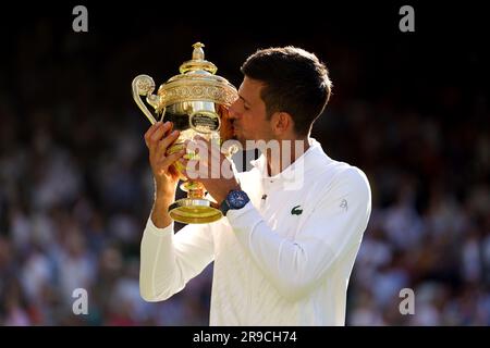 File foto datato 10-07-2022 di Novak Djokovic festeggia con il Trofeo dopo la sua vittoria su Nick Kyrgios. Dopo che Novak Djokovic si è allontanato da Rafael Nadal vincendo il suo 23° grande slam all'Open di Francia, avrà un altro obiettivo mentre arriverà al suo felice terreno di caccia. Il serbo ha vinto gli ultimi quattro titoli di singolare a Wimbledon e un altro quest'anno lo vedrà pareggiare a livello con Roger Federer a otto mentre continua a battere tutti i record nell'autunno della sua carriera. Data di emissione: Lunedì 26 giugno 2023. Foto Stock