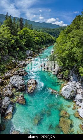 Valle Soca, Slovenia - veduta aerea panoramica del fiume alpino smeraldo Soca in una giornata estiva di sole con le Alpi Giulie, il cielo blu e la folia verde Foto Stock