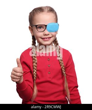 Ragazza felice con la patch per gli occhi sugli occhiali che mostra il pollice su sfondo bianco. Trattamento con strabismo Foto Stock