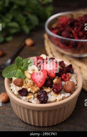 Farina d'avena con frutta liofilizzata, noci e menta su tavolo di legno Foto Stock