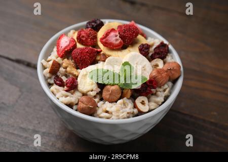 Farina d'avena con frutta liofilizzata, noci e menta su tavolo di legno Foto Stock