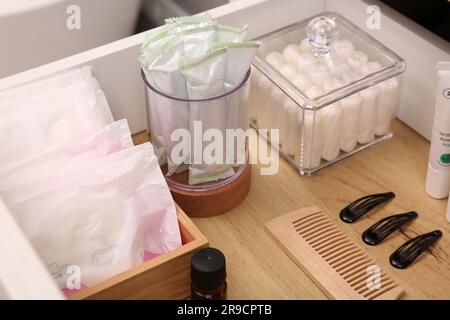 Cassetto per armadi aperto con tamponi e prodotti per l'igiene femminile in interni, primo piano Foto Stock