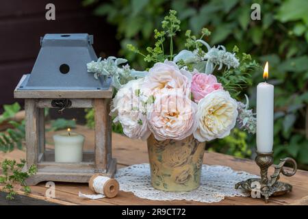 sistemazione romantica con bouquet di rose inglesi e candele Foto Stock