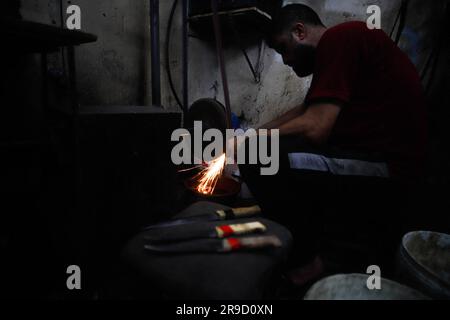 Gaza City, Palestina. 25 giugno 2023. Un impegnato laboratorio di affilatura dei coltelli nella città di Gaza, in vista delle prossime celebrazioni di Eid al-Adha il 25 giugno 2023. EID al-Adha o ''Festa del sacrificio'' è una grande festa nell'Islam che viene celebrata l'ultimo giorno del pellegrinaggio Hajj. È tradizione sacrificare un animale come una pecora o una capra durante Eid al-Adha, per ricordare l'obbedienza del Profeta Ibrahim a Dio. Foto di Habboub Ramez/ABACAPRESS.COM credito: Abaca Press/Alamy Live News Foto Stock