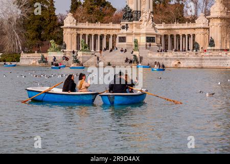 Madrid, Spagna - FEB 16, 2022: Gente che si diverte sulle barche a remi sullo stagno all'interno del Parco del Buen Retiro a Madrid, Spagna. Foto Stock