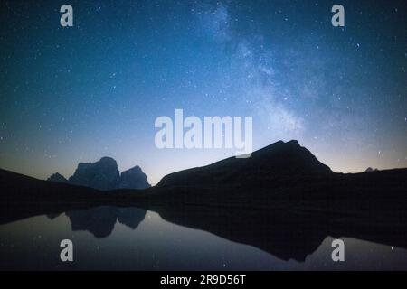 La via Lattea e le stelle di Pelmo si specchiano nel lago di Baste, Dolomiti, Italia Foto Stock