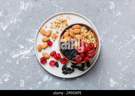 Cucinare una sana colazione. Granola con vari frutti secchi e noci in una ciotola. Il concetto di un dessert sano. Piano di giacitura, vista dall'alto con sp. Copia Foto Stock