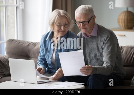 Sorridenti coppie in pensione hanno letto buone notizie sulla notifica cartacea Foto Stock