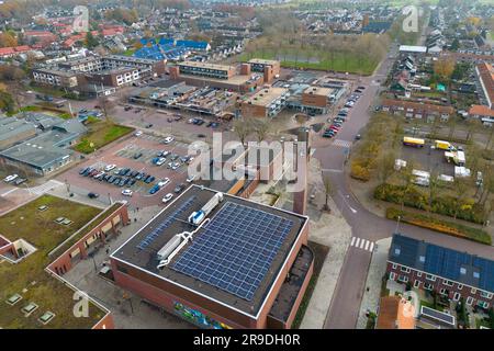 Una foto aerea con drone del centro di Biddinghuizen a Flevoland, Paesi Bassi. Potete vedere il municipio con molti pannelli solari sul tetto. Foto Stock