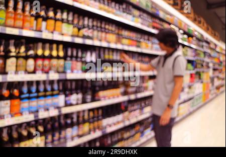 Persone sfocate astratte che fanno acquisti di liquori in un negozio al dettaglio Foto Stock