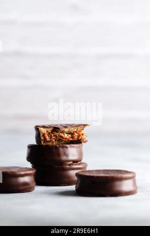 Alfajores di cioccolato fondente impilati su sfondo grigio. Foto Stock