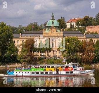 PRAGA, REPUBBLICA CECA, EUROPA - crociera in barca con turisti sul fiume Moldava, passa davanti all'edificio dell'Accademia Straka, l'ufficio del governo della Repubblica Ceca Foto Stock