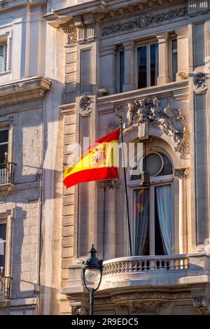 Bandiera spagnola che sventola su un palo in un balcone di un edificio classico a Madrid, in Spagna. Foto Stock