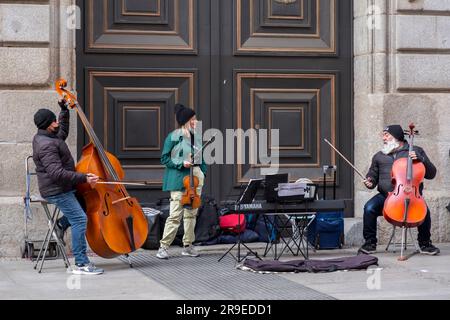 Madrid, Spagna - FEB 19, 2022: Musicisti di strada che si esibiscono con doppi violini e violino in Calle de Alcala, Madrid. Foto Stock