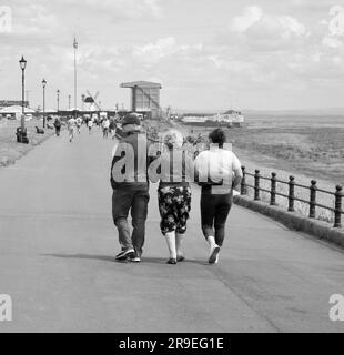 Una vista di un gruppo di famiglie mentre passeggiano lungo la passeggiata a Lytham St Annes, Lancashire, Regno Unito, Europa Foto Stock