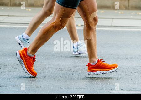 gambe ravvicinate accoppiano i corridori, uomo e donna, che corrono in maratona insieme Foto Stock