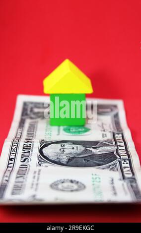 Casa formata con figure geometriche su banconota da dollaro Foto Stock