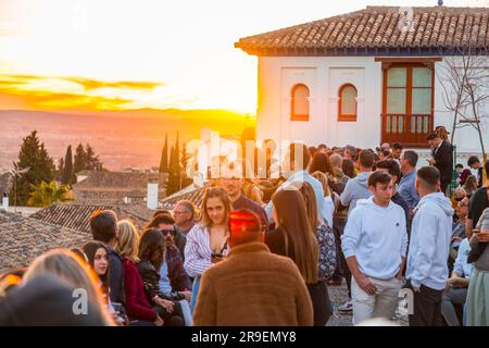 Granada, Spagna - 22 febbraio 2022: Folla di visitatori che guarda il tramonto e osserva il Palazzo dell'Alhambra dal Mirador de San Nicolas, Granada, Spai Foto Stock