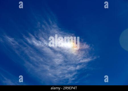 Luce solare con riflessi colorati su nuvola bianca, vista cielo blu Foto Stock