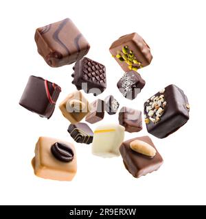 Praline di cioccolato assortite che cadono su sfondo bianco Foto Stock