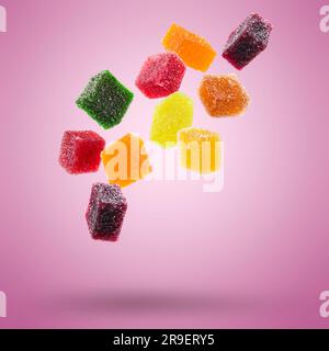 caramelle di gelatina assortite che fluttuano su sfondo colorato. Foto Stock