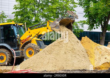 l'escavatore giallo produce lavori di terra sulla strada. l'escavatore giallo scava il terreno. Foto di alta qualità Foto Stock