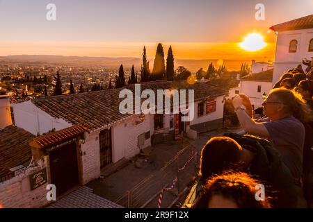 Granada, Spagna - 22 febbraio 2022: Folla di visitatori che guarda il tramonto e osserva il Palazzo dell'Alhambra dal Mirador de San Nicolas, Granada, Spai Foto Stock