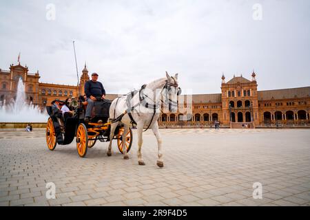 Siviglia, Spagna - 24 febbraio 2022: Carrozze turistiche intorno a Plaza de Espana, una piazza nel Parque de Maria Luisa a Siviglia, Spagna. Foto Stock