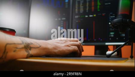 Il trader maschile, il broker utilizza e fa clic con il mouse del computer, analizza le azioni in tempo reale, visualizza i grafici di mercato su PC multi-monitor. Man lavora in remoto in investimenti o criptovalute in ufficio. Primo piano. Foto Stock