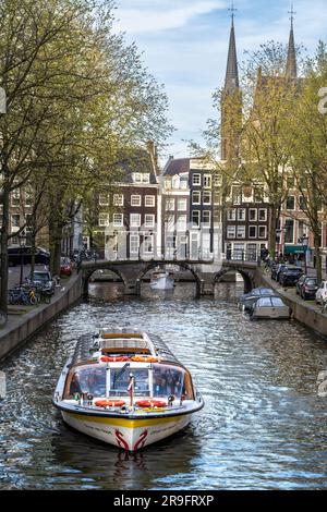 Tour in barca dei canali nell'area Jordaan di Amsterdam con le torri Posthoornkerk in lontananza Foto Stock