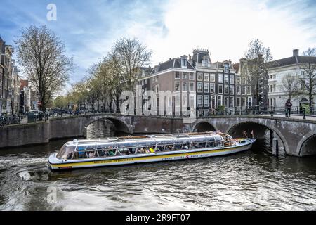 Tour in barca dei canali sotto un ponte ad Amsterdam Foto Stock