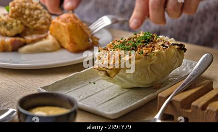 Cavolo Hispi alla griglia Char con crema di insalata e maiale croccante Foto Stock