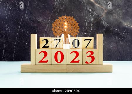 Calendario in legno a cubo con data del 27 luglio. Calendario in legno con data sul tavolo. sfoca gli oggetti sullo sfondo. Foto Stock
