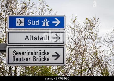 Immagine di un cartello stradale tedesco che indica varie direzioni, in particolare la strada per l'autostrada tedesca di Colonia verso sud, e il locale d Foto Stock