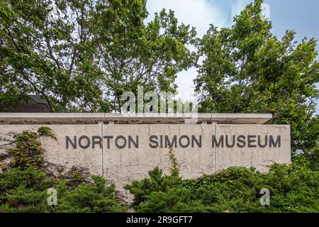 Pasadena, CA, USA - 8 giugno 2023: Museo d'arte Norton Simon. Cartello con il nome marrone sulla parete beige circondata da verde fogliame Foto Stock