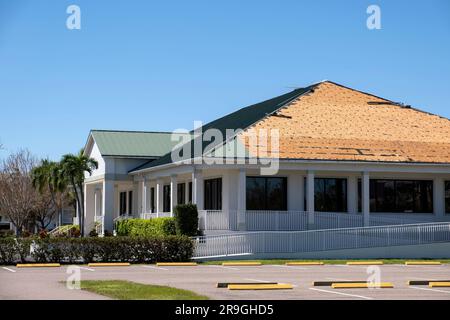 Tetto rovinato da riparare. Il vento ha danneggiato il tetto della casa con l'asfalto mancante in seguito all'uragano Ian in Florida. Foto Stock