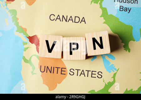 Acronimo VPN (Virtual Private Network) realizzato in cubi di legno sulla mappa del mondo, flat lay Foto Stock