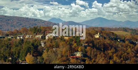 Vista dall'alto di costose case residenziali in cima a una collina tra alberi gialli cadenti nella zona suburbana del North Carolina. Case di sogno americane come Foto Stock