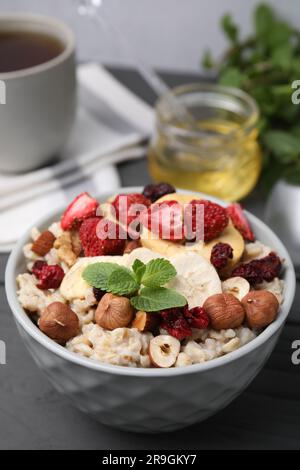 Farina d'avena con frutta liofilizzata, noci e menta su tavola grigia Foto Stock
